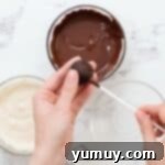 Bite Sized Chocolate Delights 12 Pushing a cake pop stick into a chocolate cake ball.