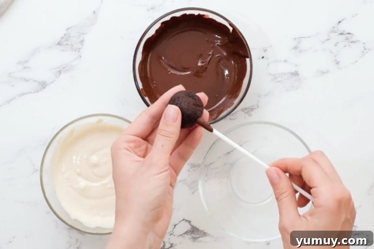 Bite Sized Chocolate Delights 21 A cake pop stick being carefully pushed into a round chocolate cake ball, secured with a dab of melted chocolate.