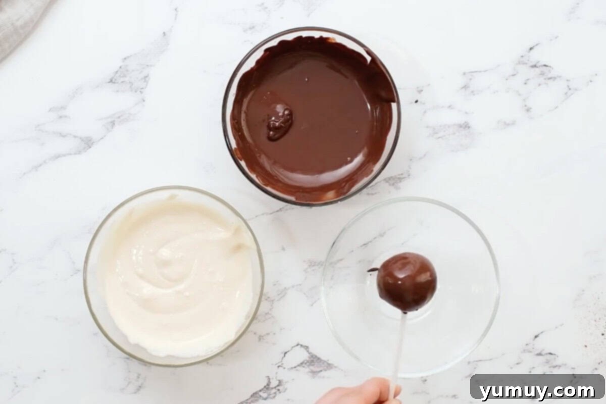 Bite Sized Chocolate Delights 22 A freshly dipped chocolate cake pop being held to allow excess chocolate to drip off, ensuring a smooth, even coating.