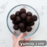 Bite Sized Chocolate Delights 10 Chocolate cake balls stacked in a glass bowl.