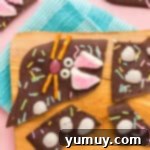 individual pieces of easter bunny chocolate bark neatly arranged on a wood board