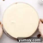 Overhead view of a perfectly baked carrot cake cheesecake cooling on a wire rack.