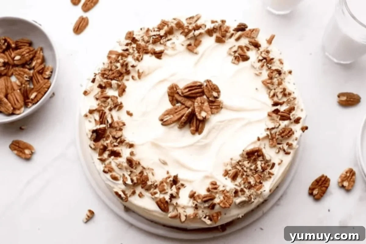 A glorious carrot cake cheesecake, generously topped with creamy cream cheese frosting and sprinkled with chopped nuts, ready to serve.
