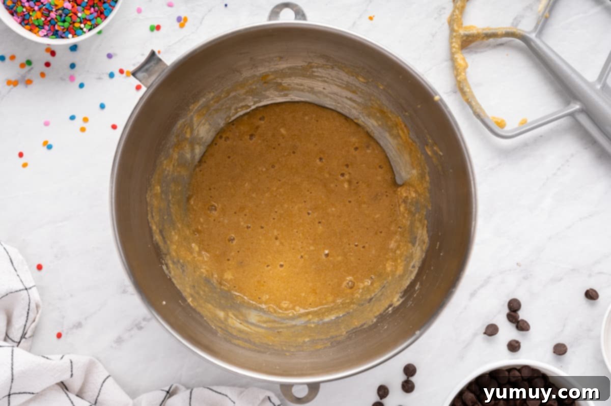 The Legendary Chocolate Chip Cookie Cake 18 wet ingredients for chocolate chip cookie cake in a metal bowl