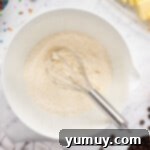 The Legendary Chocolate Chip Cookie Cake 6 dry ingredients in a white bowl with a whisk