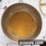 The Legendary Chocolate Chip Cookie Cake 8 wet ingredients for chocolate chip cookie cake in a metal bowl