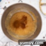 The Legendary Chocolate Chip Cookie Cake 9 wet ingredients for chocolate chip cookie cake in a metal bowl