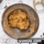 The Legendary Chocolate Chip Cookie Cake 10 cookie cake cookie dough without chocolate chips in a metal bowl