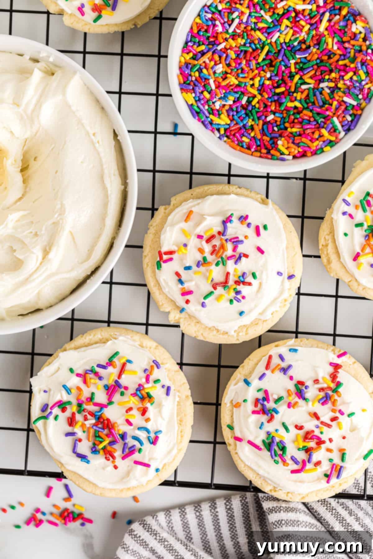 Perfectly frosted sugar cookies with festive sprinkles, arranged on a cooling rack, glistening with icing.