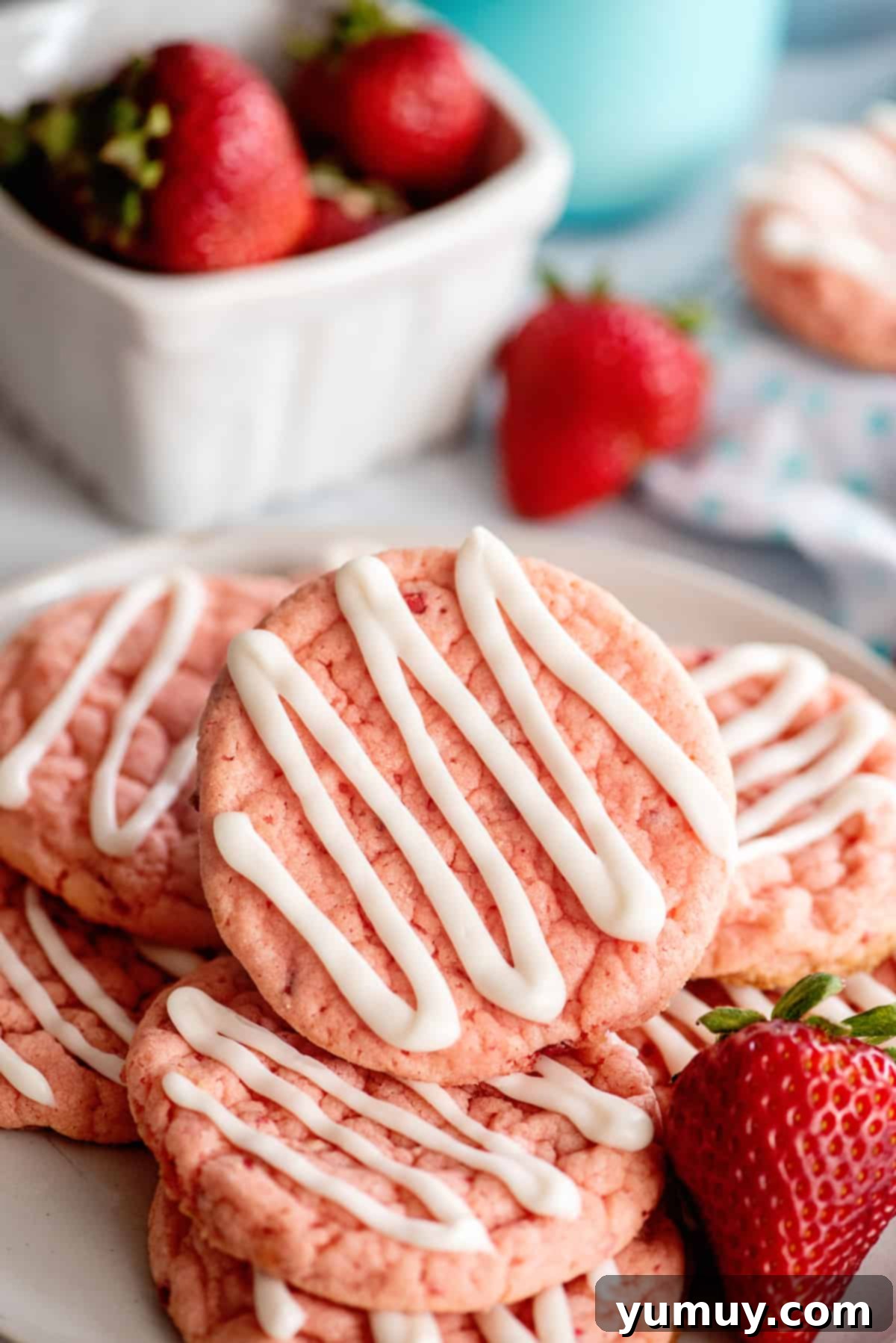 A delightful stack of soft strawberry cookies, beautifully arranged on a white plate, ready to be enjoyed.