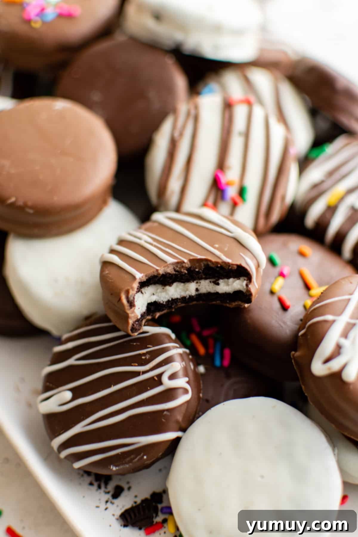 A festive pile of decorated chocolate-covered Oreos, beautifully arranged on a serving tray, perfect for a holiday treat.
