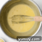 Homemade Lemon Curd: Bright, Tangy Perfection 5 Whisking lemon curd in a bowl over a double boiler.