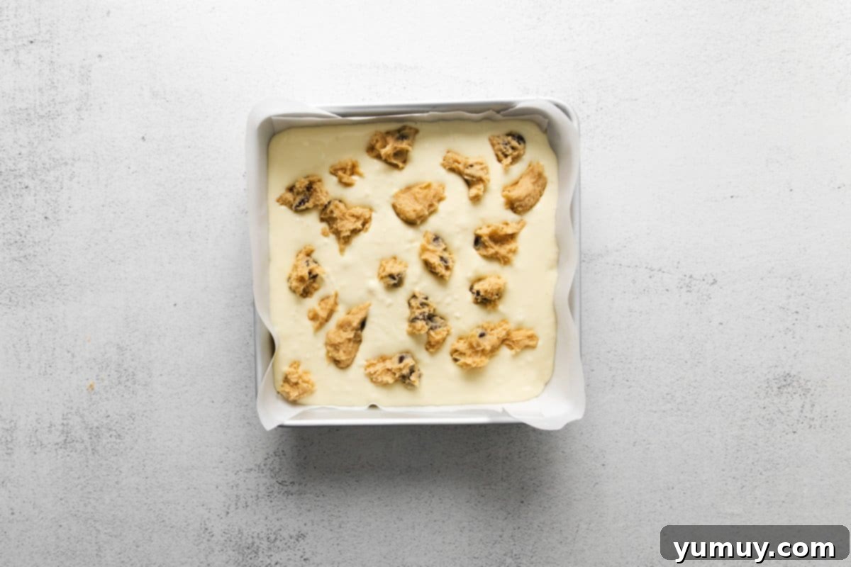 Decadent Chocolate Chip Cheesecake Squares 15 chocolate chip cookie cheesecake bars in a pan before baking