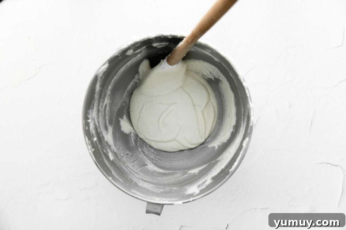 Berry Bliss Macarons 17 macaron batter in a stainless mixing bowl with a rubber spatula.