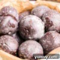 Glazed chocolate donut holes made in an air fryer in a white bowl.