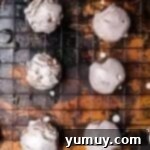 Glazed chocolate donut holes on a cooling rack.