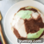 frozen ice cream dome inverted on a white plate.