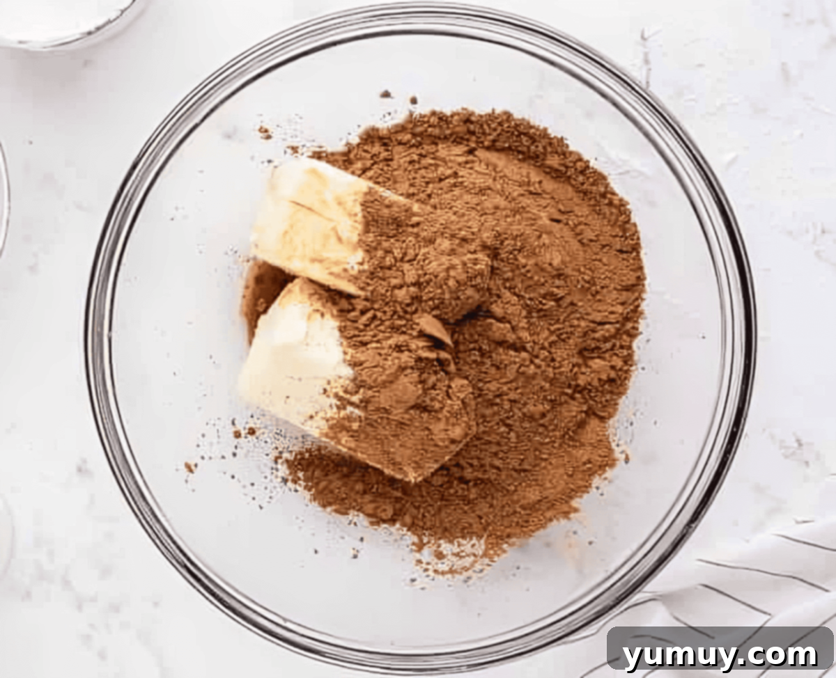 Velvet Chocolate Buttercream 10 sticks of butter and cocoa powder in a glass bowl.