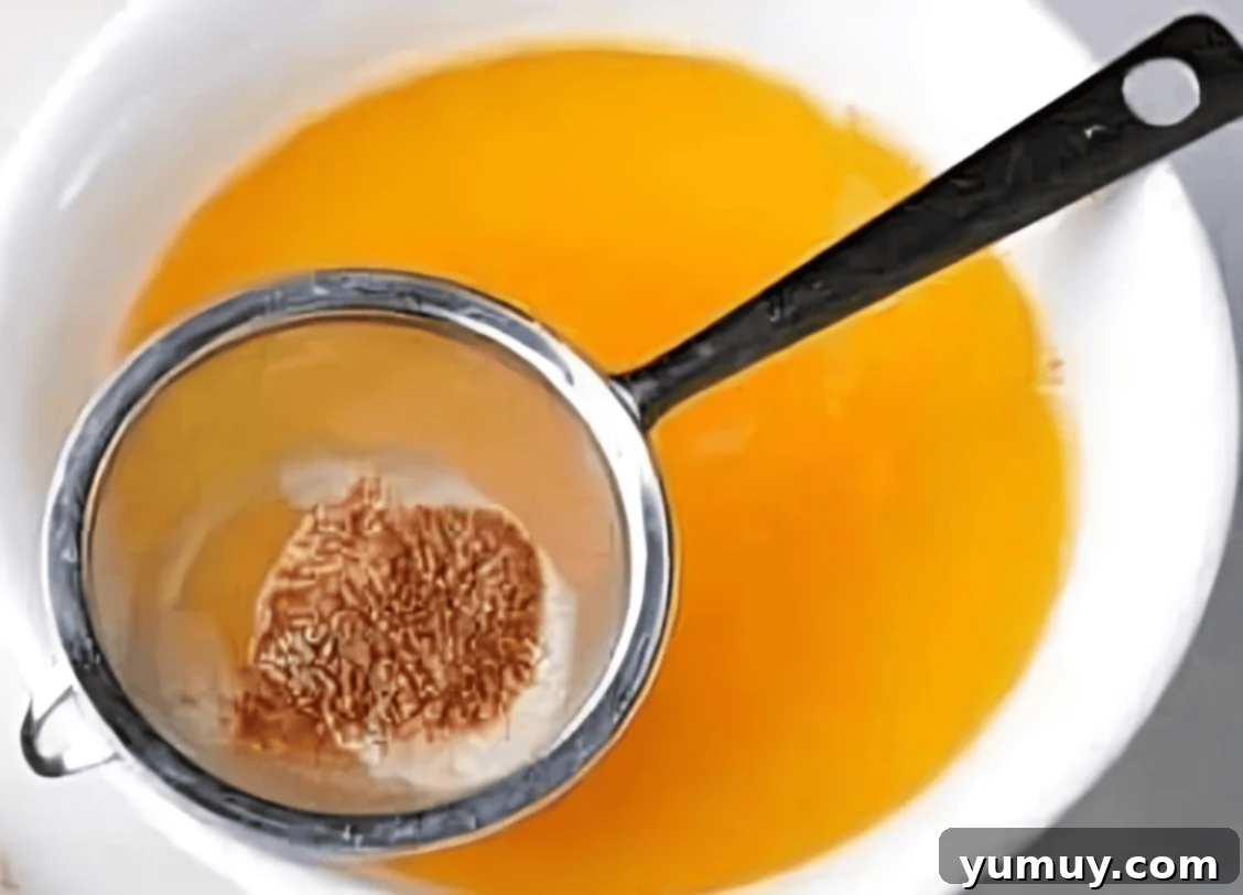 sifting brown butter into a bowl over a fine mesh sieve.