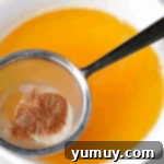 sifting brown butter into a bowl over a fine mesh sieve.