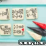 Fathers Day Cookie Creations 10 5 fathers day cookies on a blue baking sheet with red black and white frosting.