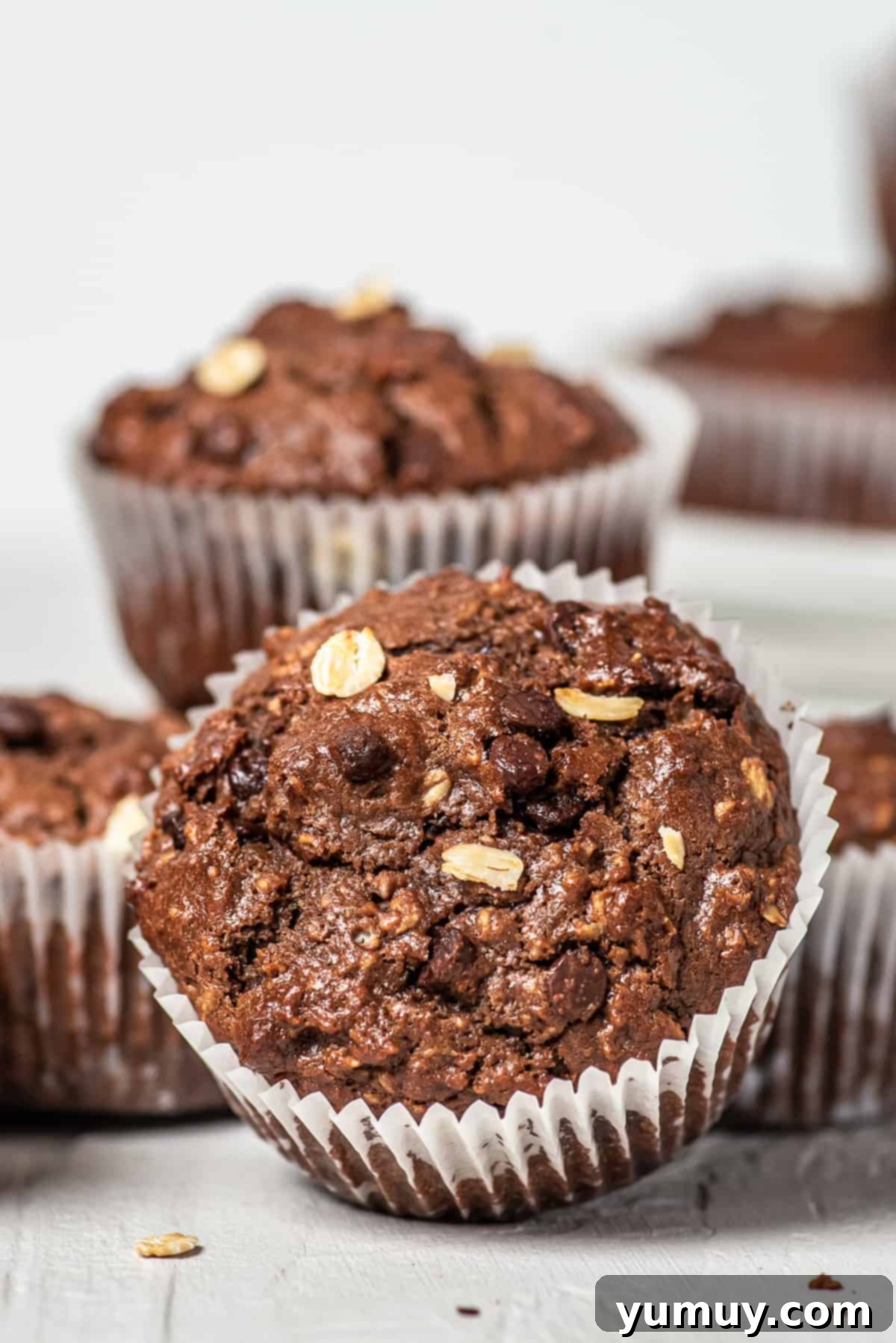 Chocolate Oatmeal Bliss Muffins 2 White table with healthy chocolate oatmeal muffins, ready for breakfast