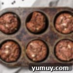 Chocolate Oatmeal Bliss Muffins 7 Chocolate oatmeal muffins baking in a muffin tin, golden brown and risen