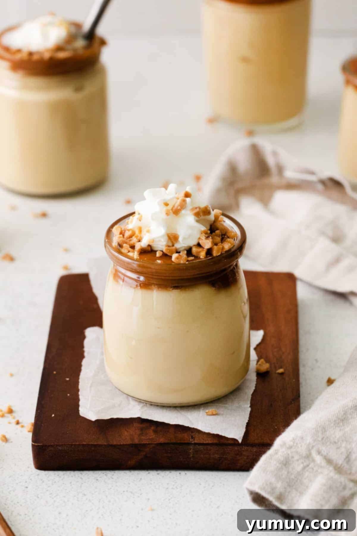 Rich Butterscotch Dream 2 Italian budino in a small jar, garnished with a sprig of mint.