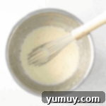 wet ingredients in a stainless mixing bowl with a whisk.