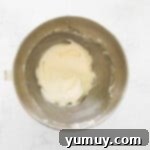 Smooth and fluffy chai tea cupcake frosting in a stainless steel mixing bowl.