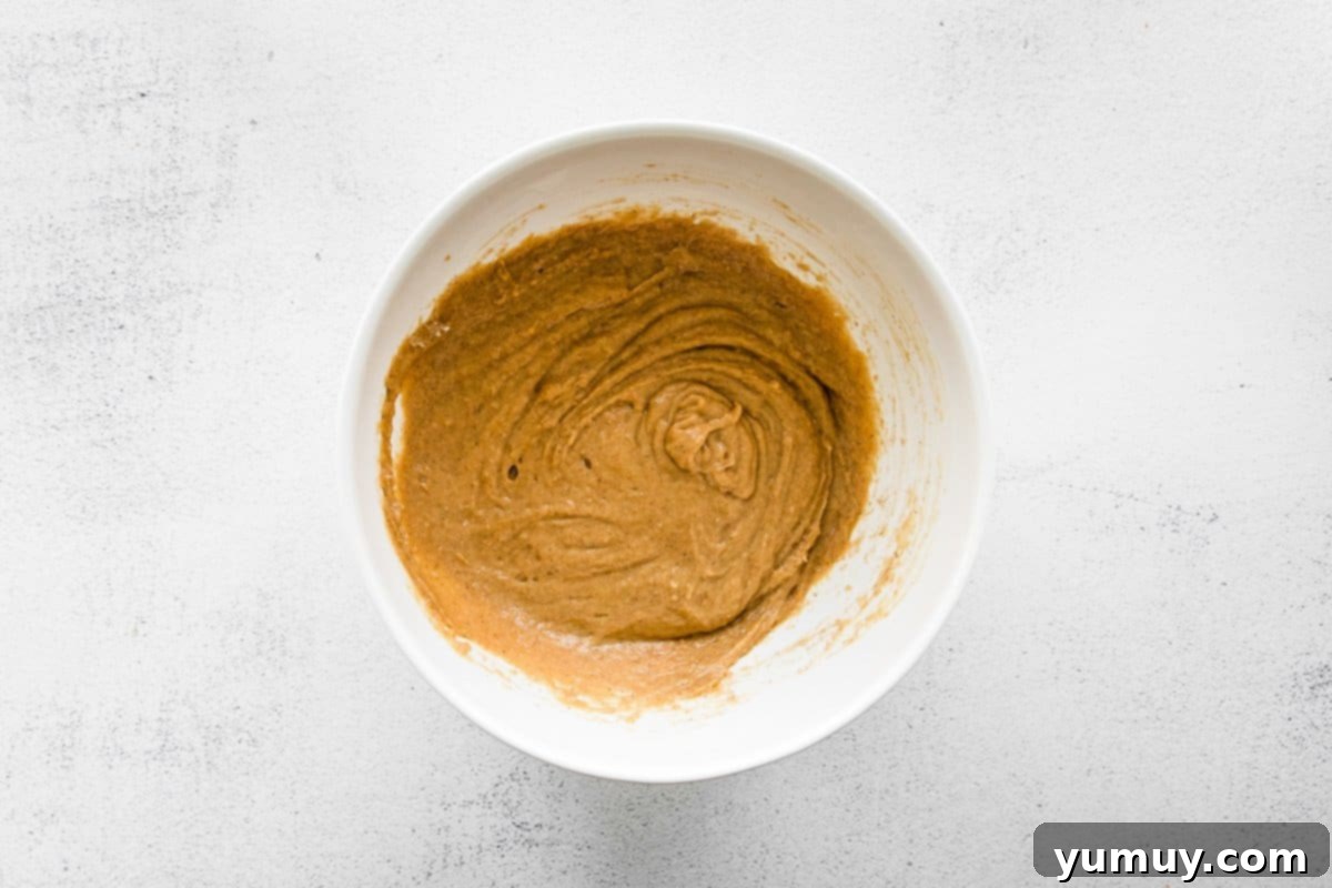 Smooth and creamy chai tea cupcake batter in a white mixing bowl, ready for baking.