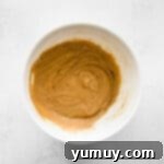 Chai tea cupcake batter, perfectly mixed, in a pristine white bowl.