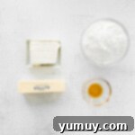 Ingredients for chai tea cupcake frosting, including butter and cream cheese, in a mixing bowl.