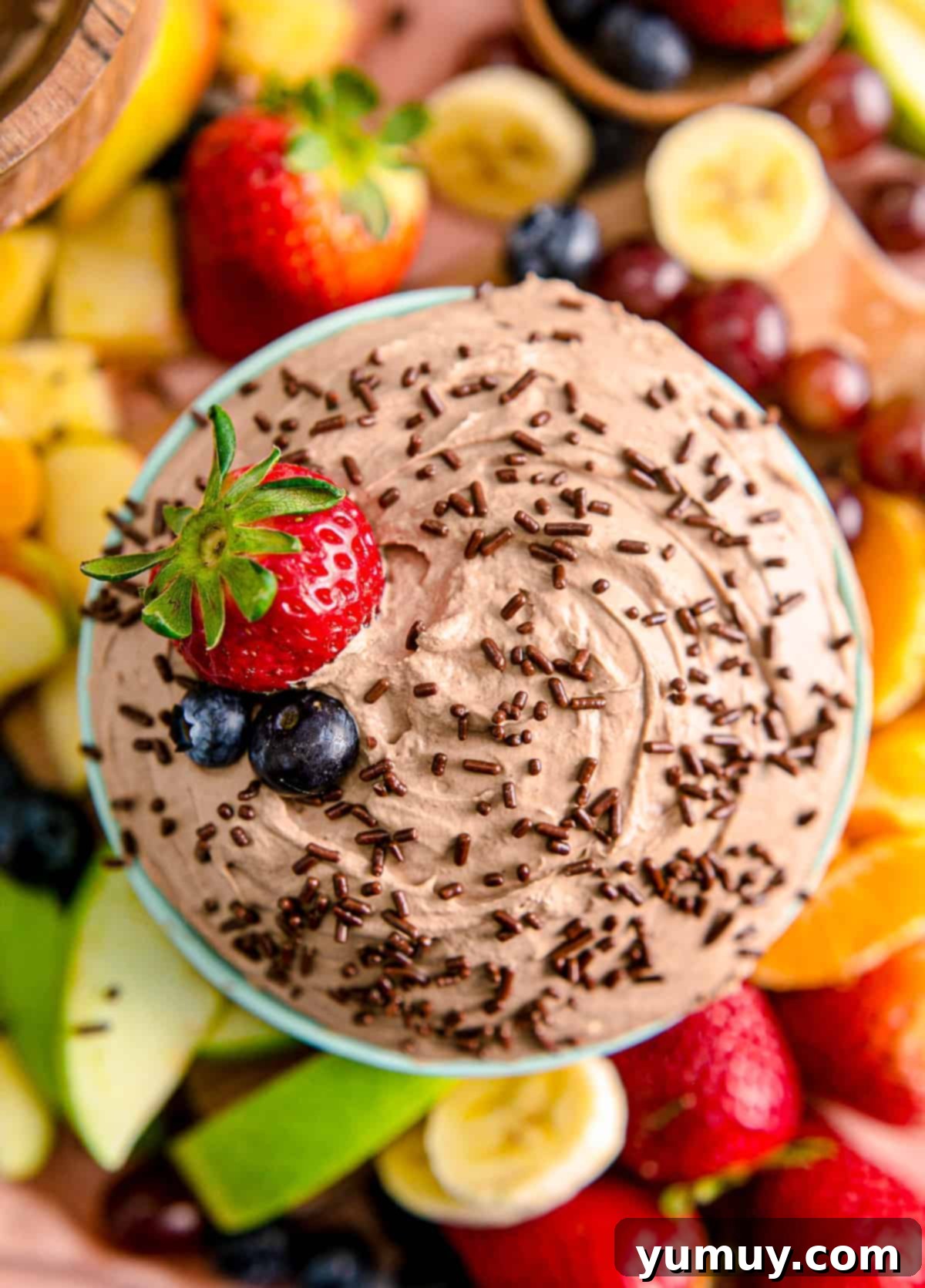 Luscious Chocolate Fruit Delight 2 A vibrant platter of fresh fruit surrounding a bowl of rich chocolate fruit dip, inviting indulgence.
