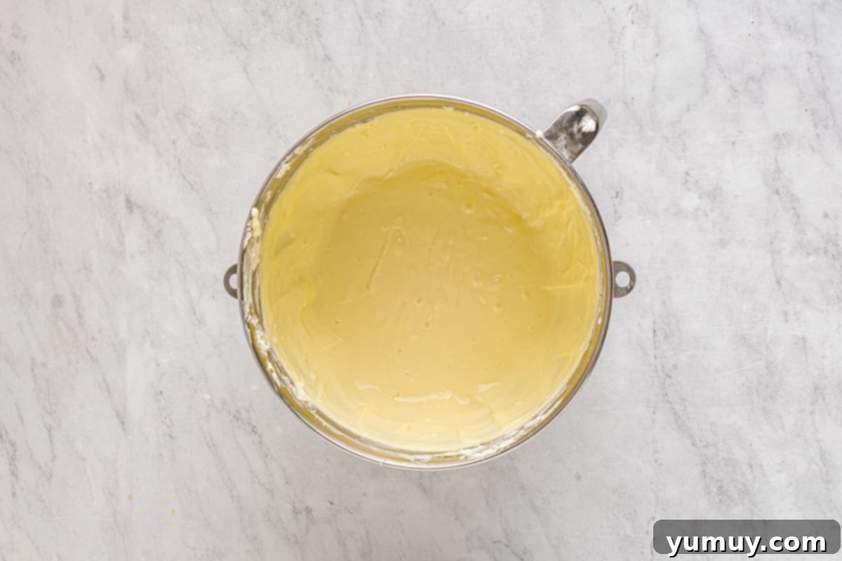Smooth cheesecake batter in the bowl of a stand mixer, ready for flavoring.