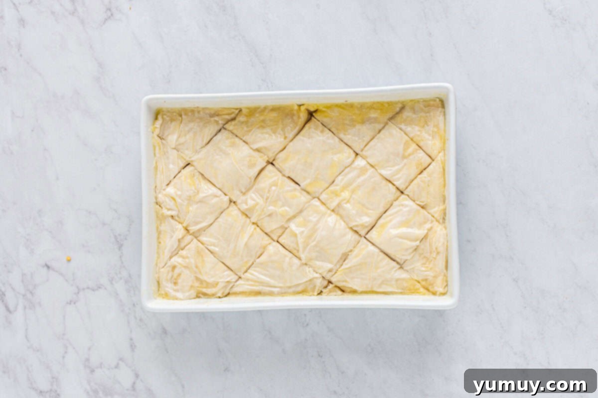 Sweet & Crispy Homemade Greek Baklava 17 The unbaked baklava meticulously scored into diamond patterns within the baking pan.