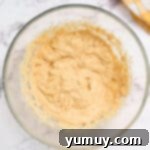 creamed wet ingredients for churro cookie dough in a glass bowl.