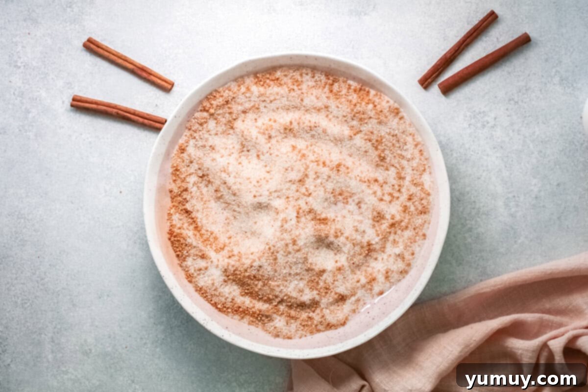 cinnamon sugar mixture for churro french toast in a white bowl, ready for dipping.