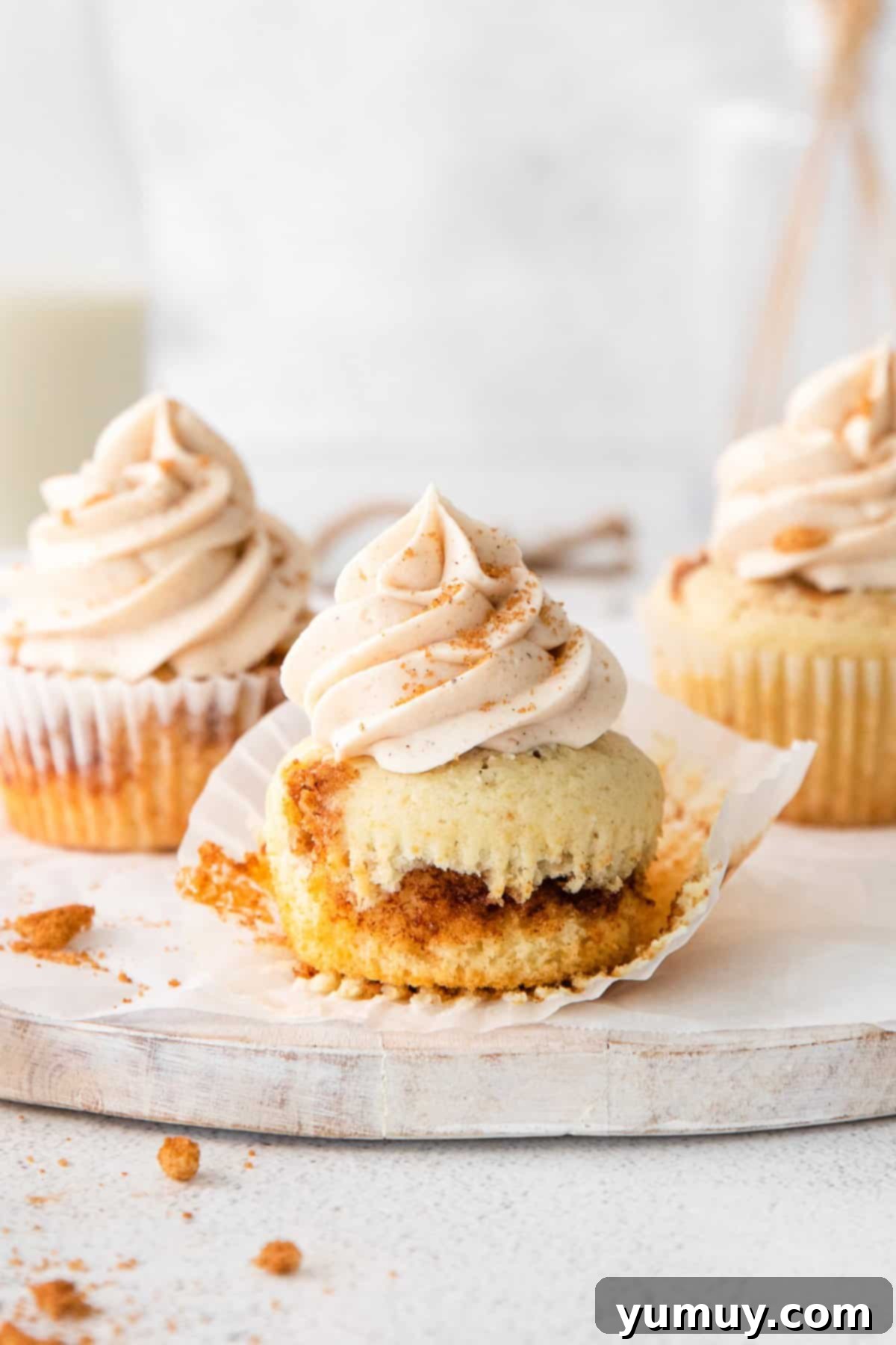 unwrapped cinnamon swirl cupcake on a marble serving platter.