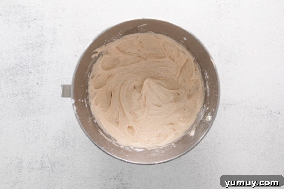 cinnamon swirl cupcake frosting in a stainless mixing bowl.