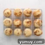 12 baked cinnamon swirl cupcakes on a wire rack.