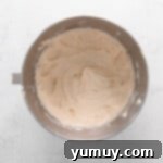 cinnamon swirl cupcake frosting in a stainless mixing bowl.