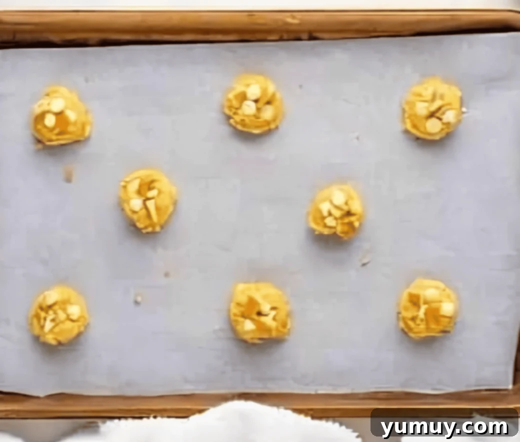 Southern Banana Pudding Cookies 16 Perfectly portioned banana pudding cookie dough balls evenly spaced on a baking sheet, ready for the oven