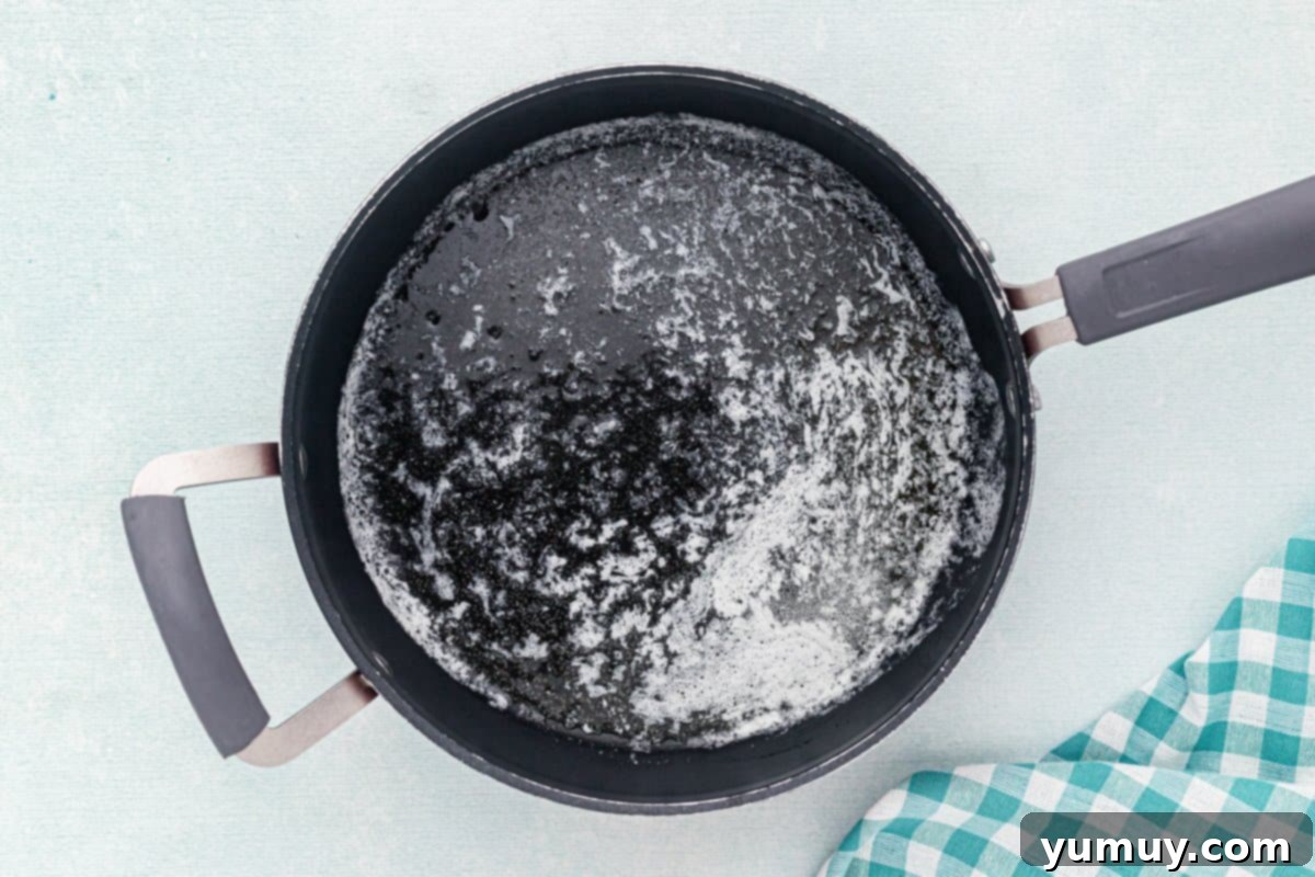 Melted butter in a saucepan, glistening on low heat.