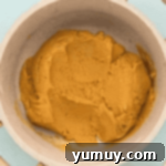 Cooked peanut butter filling stirred to a smooth, thick consistency in a saucepan.