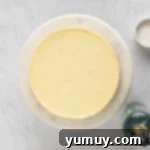 overhead view of creme brulee cheesecake on a white cake stand.