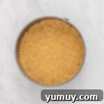 Overhead view of graham cracker crust for double crust cheesecake pressed into a springform pan.