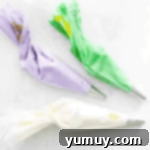 Springtime Macaron Delights 6 White, purple, and green macaron batter neatly placed in separate piping bags, ready for shaping.