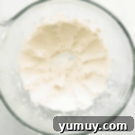 Springtime Macaron Delights 8 Creamy vanilla buttercream being mixed in a stand mixer, demonstrating the ideal fluffy texture.