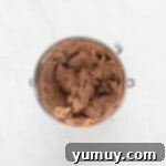 overhead view of chocolate buttercream for german chocolate cake in a stainless mixing bowl.